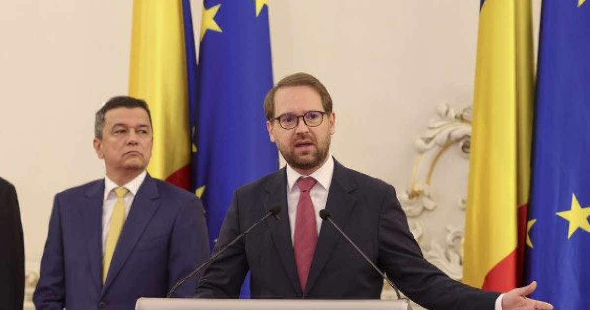 Barbat cu ochelari vorbind la microfoane