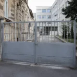 Poartă metalică și clădire veche