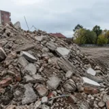 Resturi de beton și cărămizi rămase în urma demolării clădirii abandonate