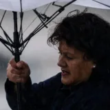Femeie sub umbrelă în timpul vântului