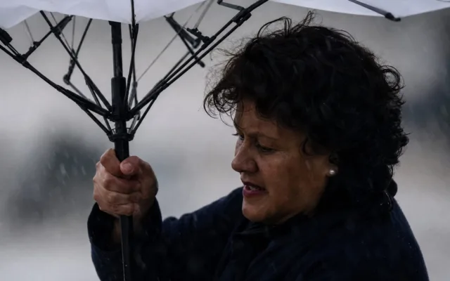 Femeie sub umbrelă în timpul vântului